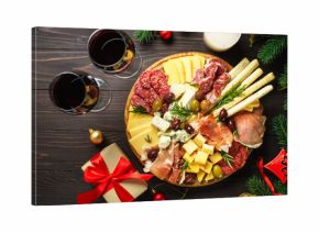 Antipasto platter with jamon, salami and cheese assortment with christmas decorations.