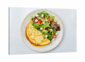 Brightly colored omelet paired with a vibrant salad featuring cucumbers, tomatoes, and greens