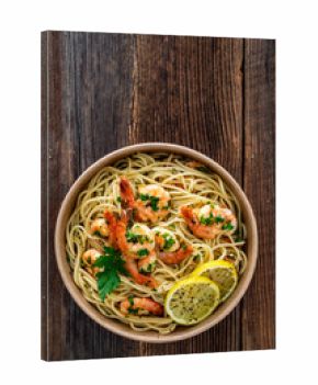 Takeaway food - fried shrimps with noodles and lemon in lunch box to go on wooden table 