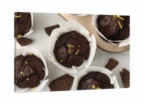 Tasty chocolate muffins with lemon zest on white table, flat lay