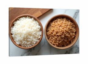 Two wooden bowls hold different uncooked rice types. One bowl has white basmati rice, the other brown medium grain. Food ingredients prepared for cooking.