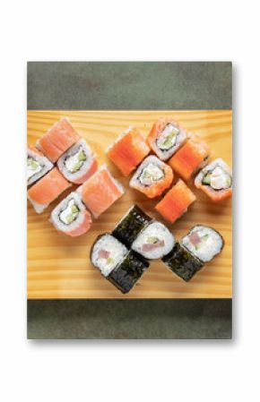 Set of sushi and maki with soy sauce on wooden plate . Top view