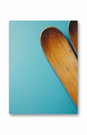 Winter ski holidays background concept image with wood vintage skis isolated on a blue backdrop with copy space