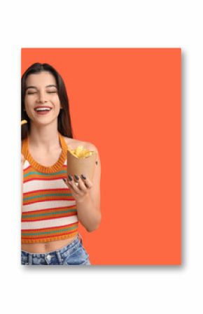 Beautiful young woman with french fries on orange background