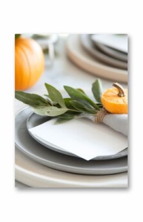 Elegant autumn table setting with pumpkins, gray plates, and fresh sage for a seasonal gathering