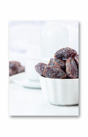 Dried medjool dates on a white table.