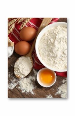 Rolling pin and ingredients for dough on wooden table, flat lay