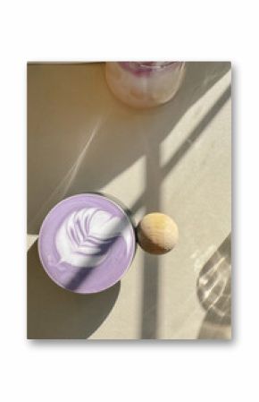 Ube latte with latte art in sunlight on neutral table