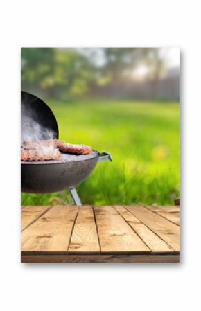 summer time in backyard garden with grill BBQ, wooden table, blurred background