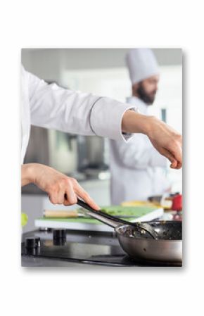 Culinary arts meet precision as a chef sprinkles parsley over a gourmet dish, ensuring a balanced gastronomy with fresh herbs. Kitchen counter filled with raw materials and fresh produce.