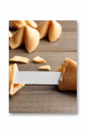 Tasty fortune cookies with predictions on wooden table, closeup. Space for text