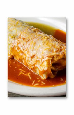 A closeup view of a red and green wet burrito.