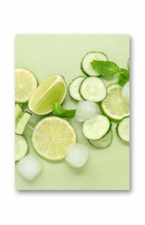 Fresh lime with cucumber, mint and ice cubes on green background. Ingredients for mojito