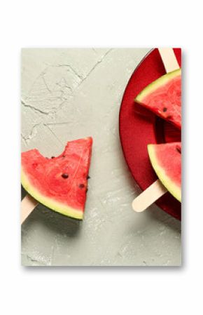 Plate with sweet watermelon sticks on grey background