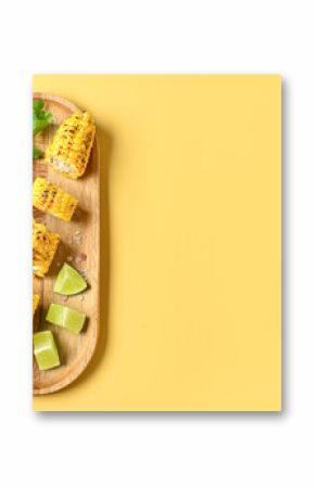 Wooden board with cut tasty grilled corn cob and sauce on yellow background