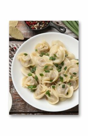 Delicious pelmeni with green onion served on wooden table, flat lay