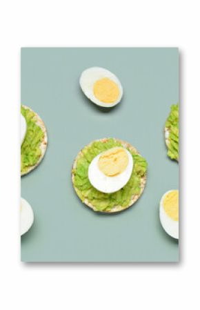 Rice crackers with boiled eggs and avocado on grey background
