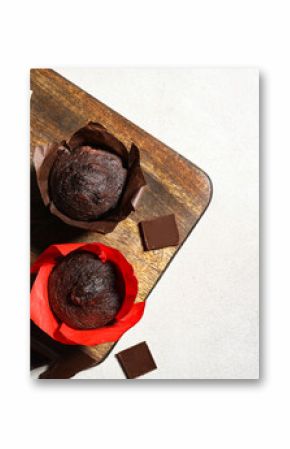 Wooden board with tasty chocolate muffins on white background