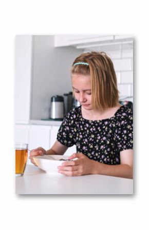 Little Girl Eating Dry Breakfast Cereal In The Kitchen For Breakfast