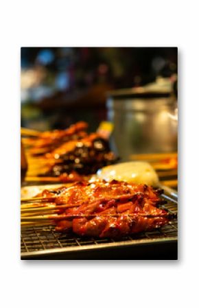 Grilled meat skewers at a night market food stall in Thailand