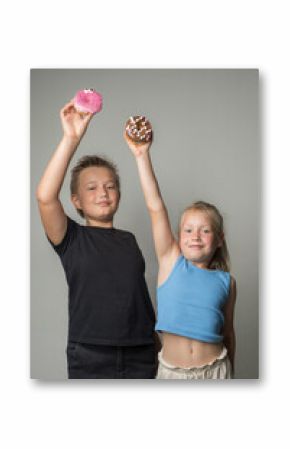 Happy children holding chocolate glazed donut indoor. Happy kids with sweet food portrait