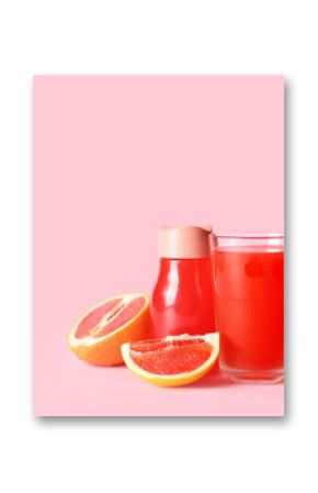 Glass and bottle with fresh grapefruit juice on pink background