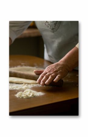 Old woman rolling dough on a table