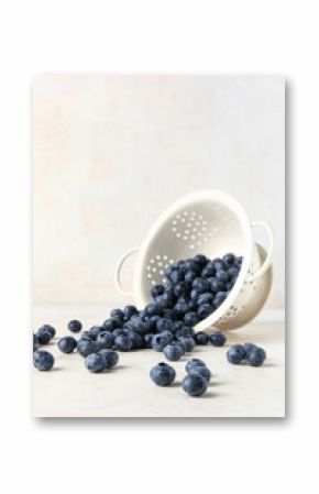 Colander with fresh blueberries on white background
