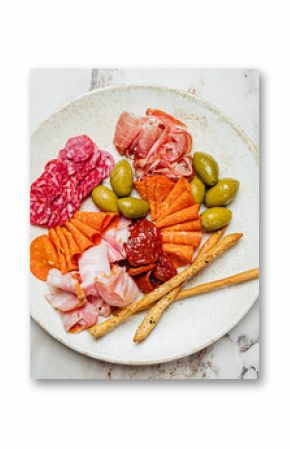 Assorted cured meats, vibrant olives, and crunchy breadsticks create a savory delicacy for sharing