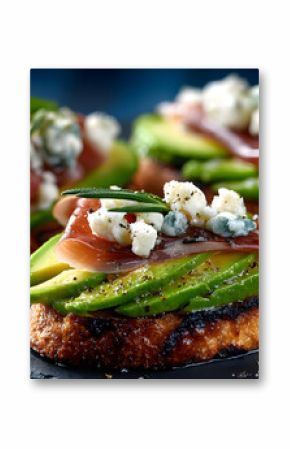 Delicious aperitifs with avocado, jamon ham serrano, cheese on toasted bread. Tasty snacks, appetizers, tapas on blue background. Fresh Mediterranean cuisine. Food photography perfect for menu banner.
