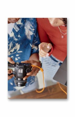 Young adult Black woman and young adult Black man reviewing digital camera images together while holding laptop, collaborating on food photography project, hands and torsos visible