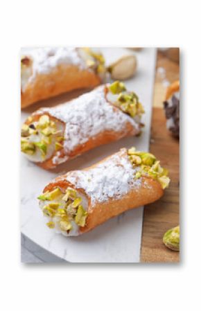 Delicious cannoli with ricotta cheese, pistachios, chocolate and powdered sugar on grey table, closeup