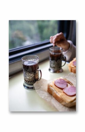 Passenger have lunch in train car by window, travel snack on table. Train meal and tea in glass holder, sandwich lunch in travel, slow living and comfortable journey, onboard snack, window seat