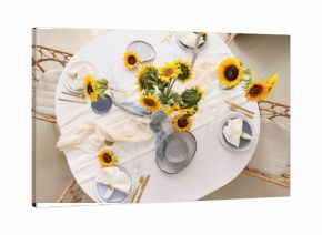 Elegant table serving with plates, folded napkins and beautiful sunflowers, top view