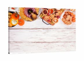 Thanksgiving appetizers, sweets and grazing boards. Above view top border on a white wood background. Pumpkin and apple snacks, pies, turkey cheese platter, desserts.