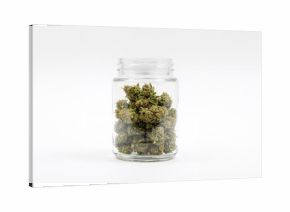 Glass container half full of marijuana isolated on white background