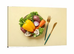 Plate with different fresh vegetables and cutlery on beige background. World Vegan Day