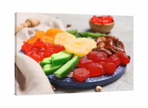 Plate with different candied fruits on grey background, closeup