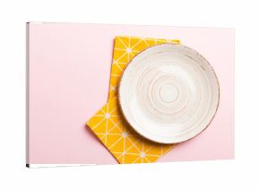 Top view on colored background empty round white plate on tablecloth for food. Empty dish on napkin with space for your design