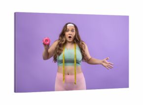 A shocked young european plus size lady in uniform stands against a purple background.