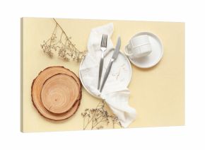 Table setting with cutlery, dishes and wooden boards on beige background