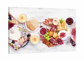 Christmas holiday charcuterie table scene on a white wood banner background. Above view. Assorted cheese, fruit and meat appetizers.