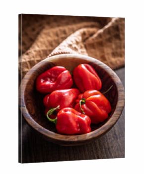 Red chili pepper habanero in bowl on wooden table.