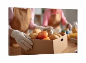 Volunteers pack grocery products for community food distribution event in local center during afternoon hours