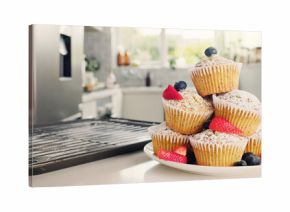 Cupcakes, kitchen and baking with fruit for sweet dessert, recipe or pastry creation in home. Empty, baked and muffin with icing sugar, strawberries or blueberries for treat or cake serving on plate