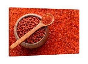 Crushed annatto seeds in the spoon and in the bowl - Bixa Orellana