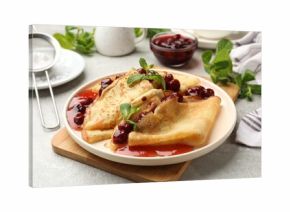 Tasty crepes with cherries, jam and mint served on light table, closeup