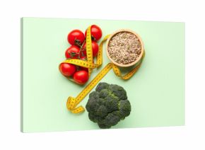 Fresh vegetables, bowl of seeds and yellow measuring tape on green background. Diet concept