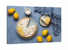 Plate with tasty lemon pie and jug of milk on blue grunge background