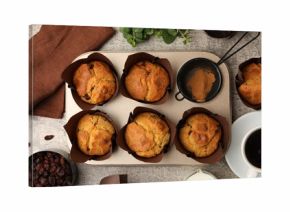 Tasty muffins with raisins, mint and coffee on grey table, flay lay